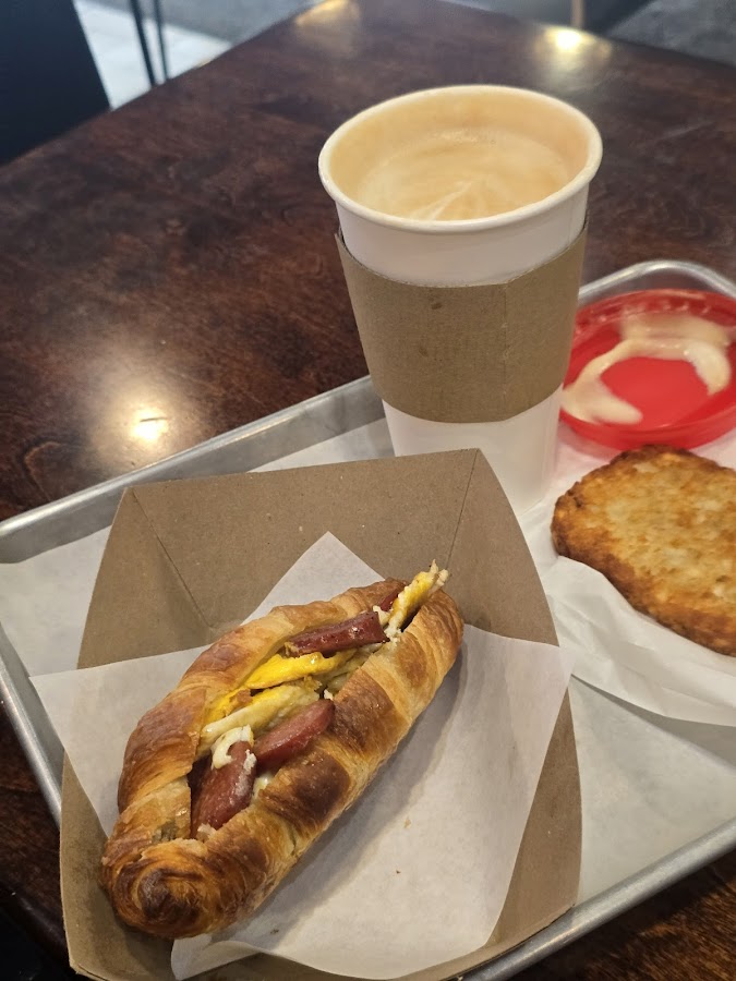 Breakfast croissant sandwich with coffee and hash brown
